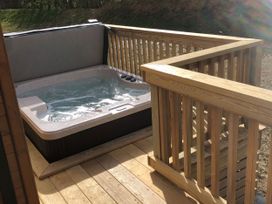 A hot tub on a wooden deck at Shangri-La in Waltham