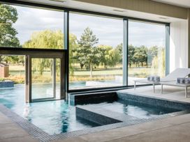 An indoor pool area with large windows and loungers at The Royal in Waltham