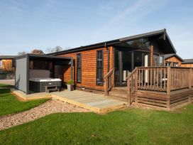 A wooden house with a hot tub on the patio at Macosi in Waltham
