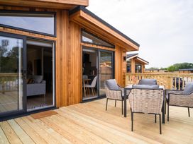 An outdoor area with wooden deck and furniture at The Luxury Retreat in Waltham