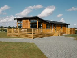A wooden house with a deck and steps at Exclusive Aura Spa in Waltham