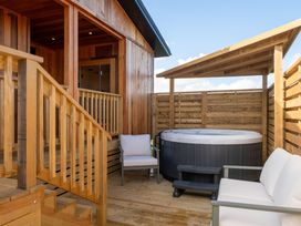 An outdoor area with a hot tub and seating at Exclusive Aura Spa in Waltham