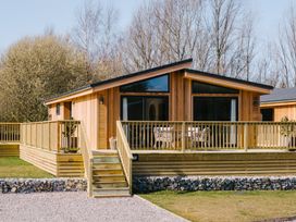 A wooden cabin with a deck and stairs at Marrakech in Waltham