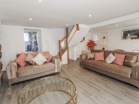 A living room with sofas and a staircase at Ty'n Lon in Pwllheli