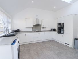 A kitchen with appliances and cabinets at Ty'n Lon in Pwllheli