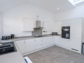A kitchen with cabinets and appliances at Ty'n Lon in Pwllheli