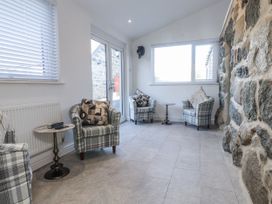 A snug with plaid armchairs and a side table at Ty'n Lon Pwllheli