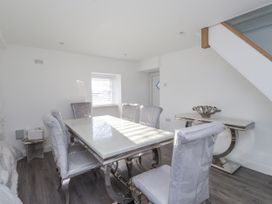 A dining room with a table and chairs at Ty'n Lon Pwllheli