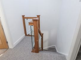 A staircase with wooden railing at Ty'n Lon Pwllheli