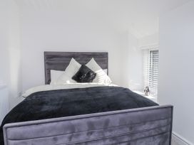 A bedroom with a bed and pillows at Ty'n Lon Pwllheli