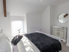 A bedroom with a bed and a cabinet at Ty'n Lon in Pwllheli