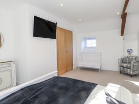 A bedroom with a bed and television at Ty'n Lon Pwllheli
