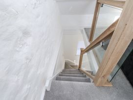 A staircase with a wooden handrail in Ty'n Lon Pwllheli