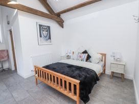 A bedroom with a bed and side tables at Ty'n Lon Pwllheli