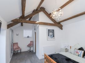 A bedroom with a bed and two chairs at Ty'n Lon in Pwllheli