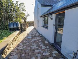 An outdoor pathway next to a house with a stone wall at Ty'n Lon Pwllheli