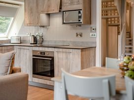 A kitchen with appliances and a dining table at St Ives Studio Spa in Praze-An-Beeble
