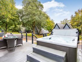 An outdoor area with a hot tub and seating at St Ives Studio Spa in Praze-An-Beeble
