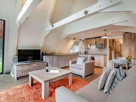 A living room with a television and kitchen units at St Ives Studio Spa, Praze-An-Beeble