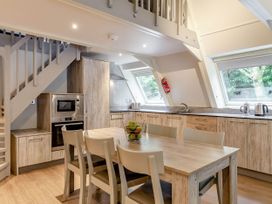 A kitchen with a dining table and chairs at St Ives Lodge 3 Spa in Praze-An-Beeble