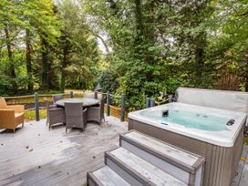An outdoor area with a hot tub and dining furniture at St Ives Lodge 3 Spa Praze-An-Beeble