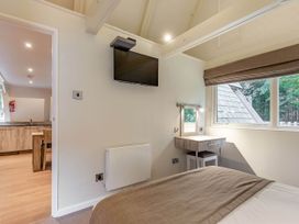 A bedroom with a television and desk at St Ives Lodge 3 Spa Praze-An-Beeble