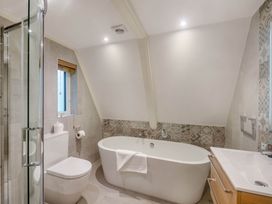 A bathroom featuring a bathtub, toilet, sink, and shower at Glass Lodge, Praze-An-Beeble