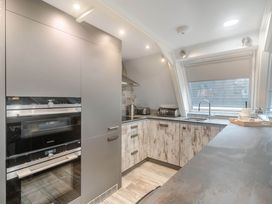 A kitchen with appliances and cabinets at Glass Lodge in Praze-An-Beeble