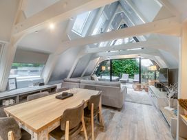 A living room with a sofa and dining table at Glass Lodge in Praze-An-Beeble
