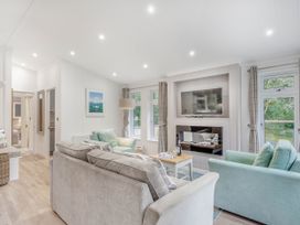A living room with sofa and television at Aubyn Lodge Spa in Praze-An-Beeble