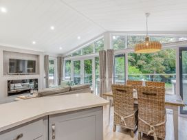 A dining room with a television and sofa at Aubyn Lodge Spa Praze-An-Beeble