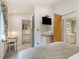 A bedroom with a desk and lamp at Aubyn Lodge Spa Praze-An-Beeble