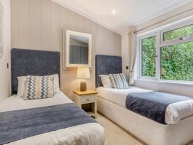 A bedroom with two single beds and a bedside table at Aubyn Lodge Spa in Praze-An-Beeble
