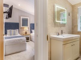 A bedroom with two beds and a bathroom area at Aubyn Lodge Spa Praze-An-Beeble