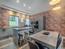 A kitchen with an island and stools at Coach House in Praze-An-Beeble