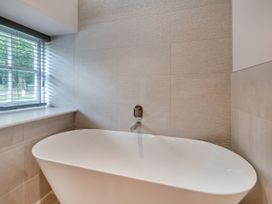 A bathroom with a bathtub and a window at Coach House in Praze-An-Beeble
