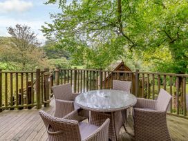 An outdoor dining area with a circular table and chairs at The Treehouse in Praze-An-Beeble