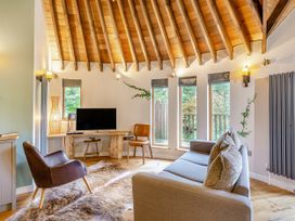 A living room with a television, sofa, and chair at The Treehouse in Praze-An-Beeble