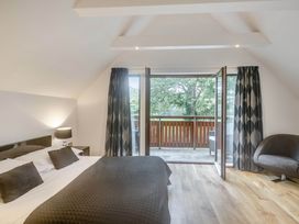 A bedroom with a bed and sliding doors to a balcony at Cornwall Lodge Spa in Praze-An-Beeble