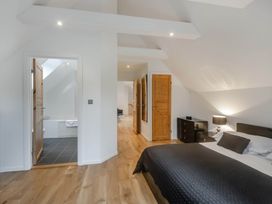 A bedroom with bed, nightstand, and an en-suite bathroom at Cornwall Lodge Spa in Praze-An-Beeble