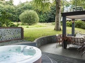 An outdoor area with a hot tub and seating at St Austell Lodge Spa in Praze-An-Beeble