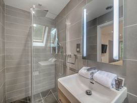 A bathroom with a shower and sink at St Austell Lodge Spa in Praze-An-Beeble