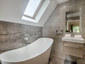 A bathroom with a bathtub and sink at St Austell Lodge Spa in Praze-An-Beeble
