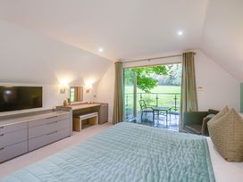 A bedroom with a television and balcony at St Austell Lodge Spa in Praze-An-Beeble