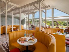 A dining room with booths and tables at St Austell Lodge Spa in Praze-An-Beeble