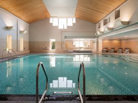 An indoor pool with water and loungers at St Austell Lodge Spa in Praze-An-Beeble