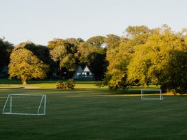 An outdoor field with goalposts and trees at St Austell Lodge Spa in Praze-An-Beeble
