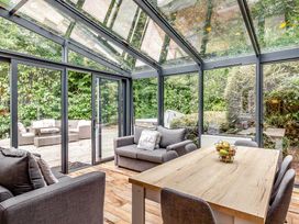 A conservatory with seating and a table at The Gatehouse in Praze-An-Beeble