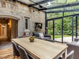 A conservatory with a dining table and chairs at The Gatehouse in Praze-An-Beeble