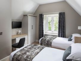 A bedroom with two beds and a desk at The Gatehouse in Praze-An-Beeble